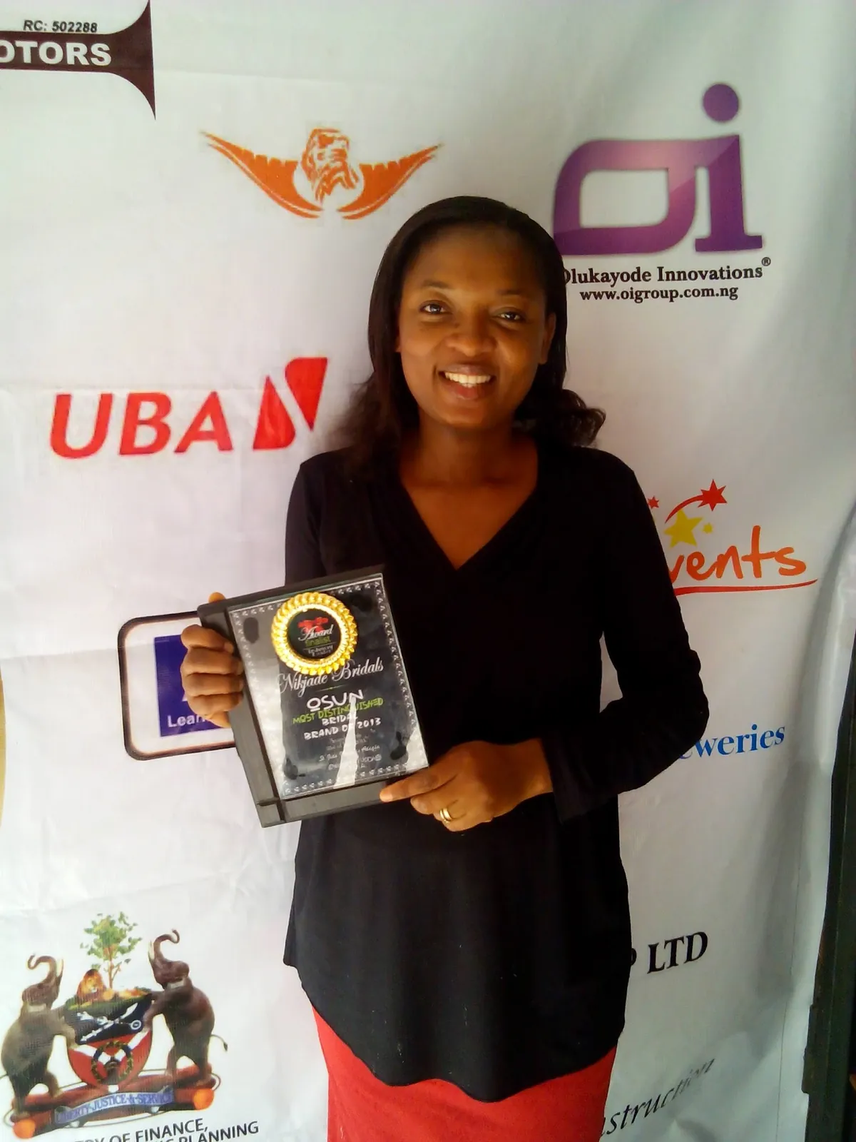 Nikjade's founder holding an award plaque presented to Nikjade Bridals
