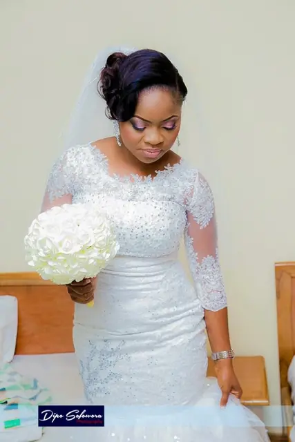 Bride in a fitted lace mermaid gown with white bouquet